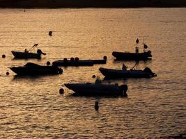 Backlighting of sport boats at anchor in a bay photo