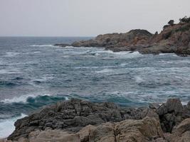 Rough sea, waves crashing against the rocks photo