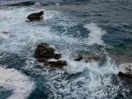 Rough sea, waves crashing against the rocks photo