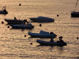 Backlighting of sport boats at anchor in a bay photo