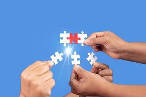 Hands holding jigsaw puzzles piece with clear blue background, success business, solution strategy, teamwork partnership concept photo