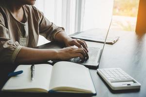 empresaria profesional que trabaja en el escritorio en la oficina. documento gráfico de análisis de mano de mujer de negocios financiero en papeleo con datos de gráfico e informe de crecimiento de marketing en la mesa. foto