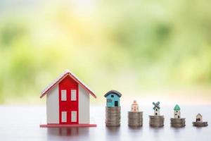 House model and money coins stacks with blur nature background. Savings plans for home, loan, investment, mortgage, finance and banking about house concept. photo