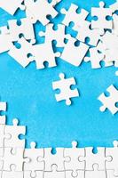 White part of jigsaw puzzle pieces on blue background. concepts of problem solving, business success, teamwork, Team playing jigsaw game incomplete, Texture photo with copy space for text