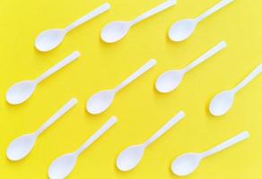 white plastic spoon placed on a yellow background photo