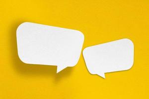 speech balloon shape white paper isolated on yellow background photo