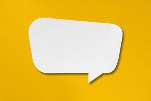 speech balloon shape white paper isolated on yellow background photo