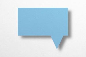 Speech balloon shaped blue paper isolated on white background. photo