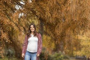 joven mujer embarazada en el parque otoño foto