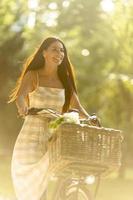 Young woman with flowers in the basket of electric bike photo