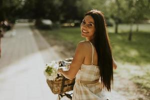 Young woman with flowers in the basket of electric bike photo