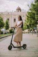 Young woman riding an electric scooter on a street