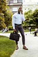 Young African American businessman using a mobile phone on a street photo