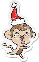 crazy distressed sticker cartoon of a monkey running wearing santa hat vector