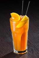 Fresh exotic cocktail with ice cubes and orange