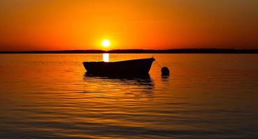 barco en el mar con hermosa puesta de sol foto