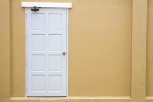 vintage clásico de puerta blanca en el fondo de pared de color amarillo