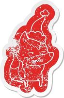 cartoon distressed sticker of a wolf showing teeth wearing santa hat vector