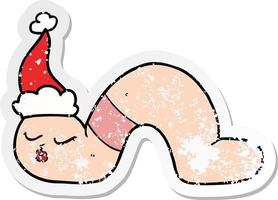 distressed sticker cartoon of a worm wearing santa hat vector