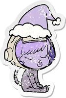 distressed sticker cartoon of a pretty astronaut girl sitting waiting wearing santa hat vector