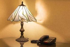 table lamp and phone on desk photo