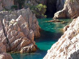 rocks and cliffs with blue sky and turquoise sea photo