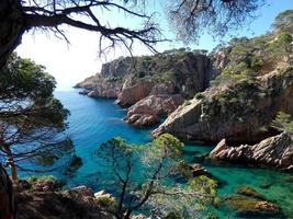 rocks and cliffs with blue sky and turquoise sea photo