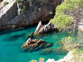 rocks and cliffs with blue sky and turquoise sea photo