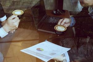 Two businessman discussing their chart in coffee shop photo