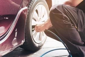 Technician is inflate car tire - car maintenance service transportation safety concept photo
