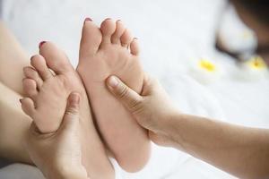 Woman receiving foot massage service from masseuse close up at hand and foot - relax in foot massage therapy service concept photo