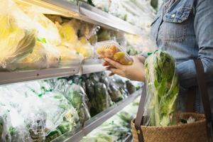 Lady is shopping fresh vegetable in supermarket store - woman in fresh market lifestyle concept photo