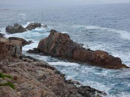 mar agitado, olas rompiendo contra las rocas foto