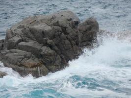 Rough sea, waves crashing against the rocks photo