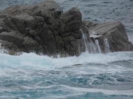 Rough sea, waves crashing against the rocks photo