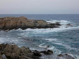 Rough sea, waves crashing against the rocks photo