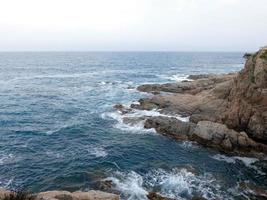 Rough sea, waves crashing against the rocks photo