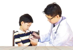 Sick Asian boy being examined by male doctor isolated over white photo