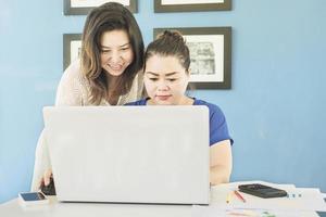 Two business women are working with computer in the office photo