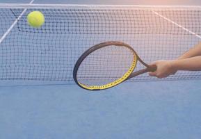 Man holding racket about to hit a ball in tennis court photo