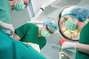 Low Angle Shot of Professional surgeons team performing surgery in operating room, surgeon, Assistants, and Nurses Performing Surgery on a Patient, health care cancer and disease treatment concept photo