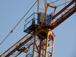 grúa en el trabajo en un sitio de construcción que transporta materiales foto