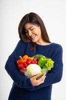 retrato de una hermosa mujer asiática sonriente sosteniendo un tazón lleno de verduras orgánicas frescas aisladas de fondo blanco, concepto de nutrición alimentaria saludable, concepto de nutrición alimentaria saludable, vegetariana
