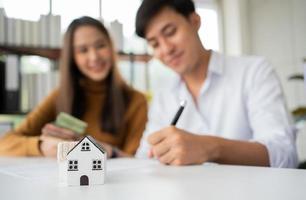 Client signs home loan document to buy homes with real estate property agent or lawyer. Real estate agent and customer signing contract to buy a house. Concept of insurance or loan real estate photo