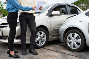 Two Drivers using a smartphone to exchange phone numbers and social media after a car accident. Concept of claim insurance for a car accident online after send photo and evidence to insurance company