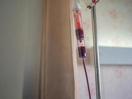 bolsa de sangre para que el paciente trate la anemia colgada en la habitación del paciente en el hospital foto