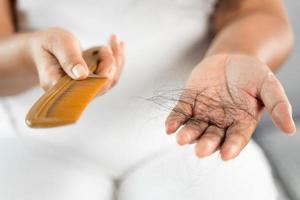 problema de caída de cabello. mujer asiática con problema de peine y cabello. pérdida de cabello del peine. conceptos de belleza y cuidado del cabello. foto