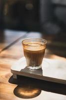 A glass of espresso shot over cold fresh milk. Dirty Coffee, Coffee menu, Milk Coffee photo