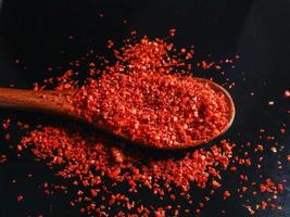 A spoonful of Red Pepper Powder black background. Selective focus photo