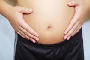 Fat boy touched his belly. Health, treatment and exercise concept. photo